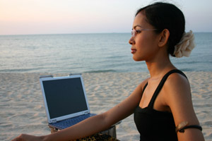 woman w/ laptop on beach